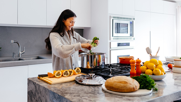 woman smiling while cooking