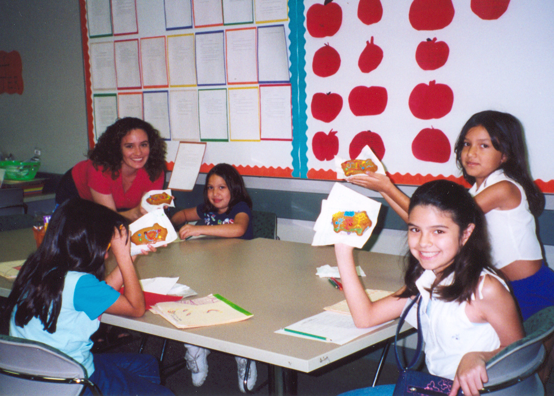 Children smilng as they complete colorful activities with a teacher