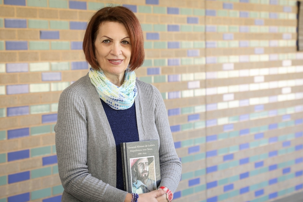 Lola Orellano Norris holds her book