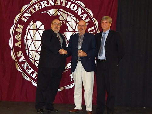 Image of Dr. Arenaz presenting award to Dr. Dan Mott