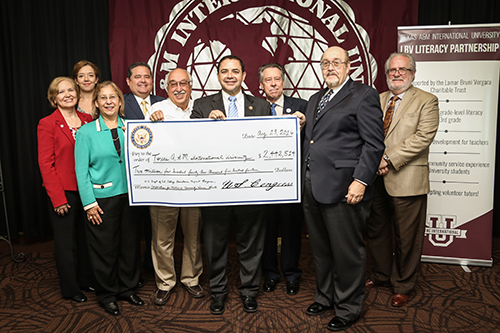 Image of Dr. Arenaz accepting award on behalf of TAMIU